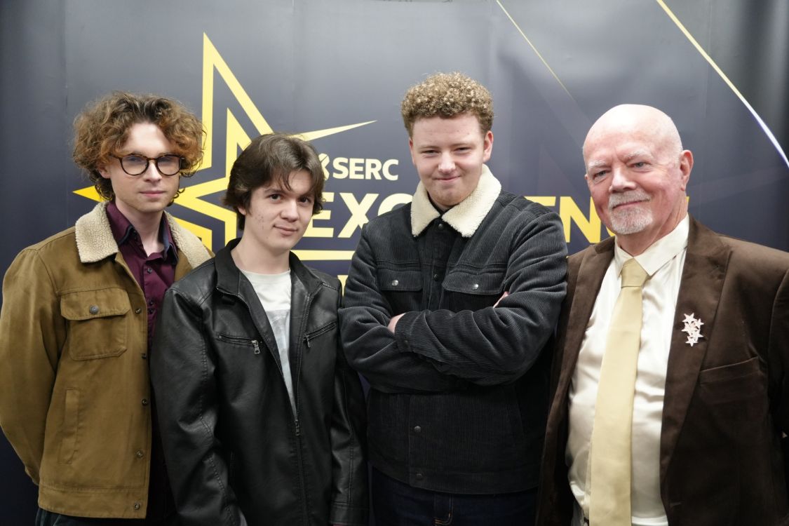 Three students with Paul Finnegan, far right.